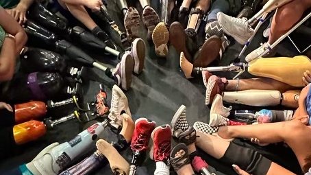 circle of legs. Students sit in a circle with their various prosthetic legs in the middle. Possibly the most expensive game of the hokey pokey ever pictured.